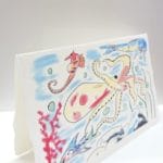 Postcards di Auguri pieghevole in carta di Amalfi. L'illustrazione rappresenta un fondale marino ricco di pesci e di biodiversità.