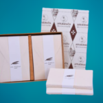 Box with wedding invitations and stationery made of Amalfi paper with a pinkish ivory color.