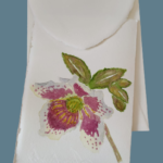 Amalfi paper invitations with watercolor flower decorations. On the cover of this model there is an hellebore flower.