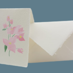 Partecipazioni floreali in carta di Amalfi. Per questo modello la pagina di copertina è stata elegantemente decorata con un ramo di bouganvillea in fiore.