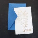 Christmas cards in Amalfi paper with golden embossed decorations handmade by Lo Scrigno di Santa Chiara. On the cover the decoration represents the stylized face of Santa Claus and the letters of his peculiar laugh.