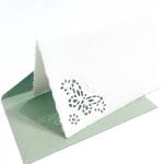Folding cards decorated with fretwork of a daisy flower and green colored envelopes in Amalfi paper. Envelope size: 14*9 cm. Card size. 13*8 cm.