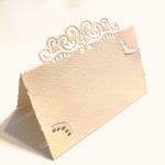 Segnaposti con traforo in stile arabesco su carta di amalfi colore avorio rosato.